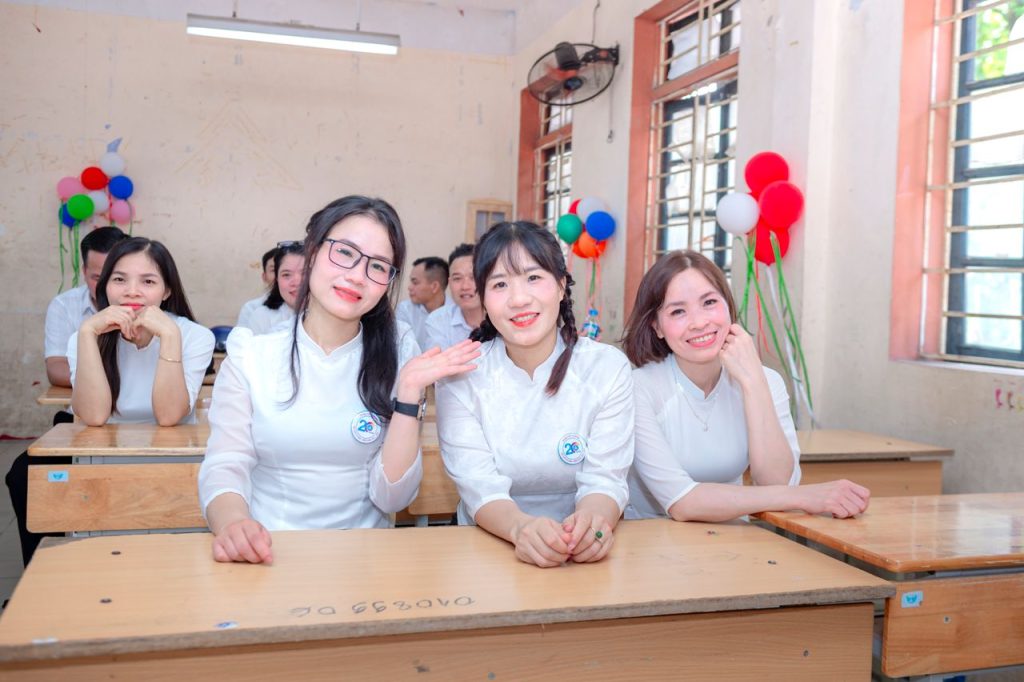 Cheerful students in a classroom setting with balloons, signifying celebration.